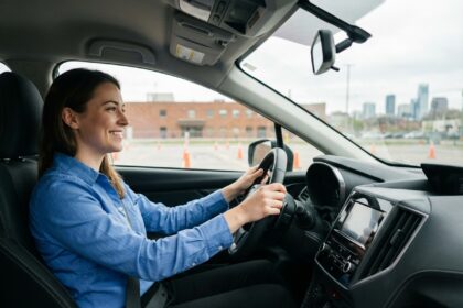 Jeune femme souriante au volant d'une voiture moderne